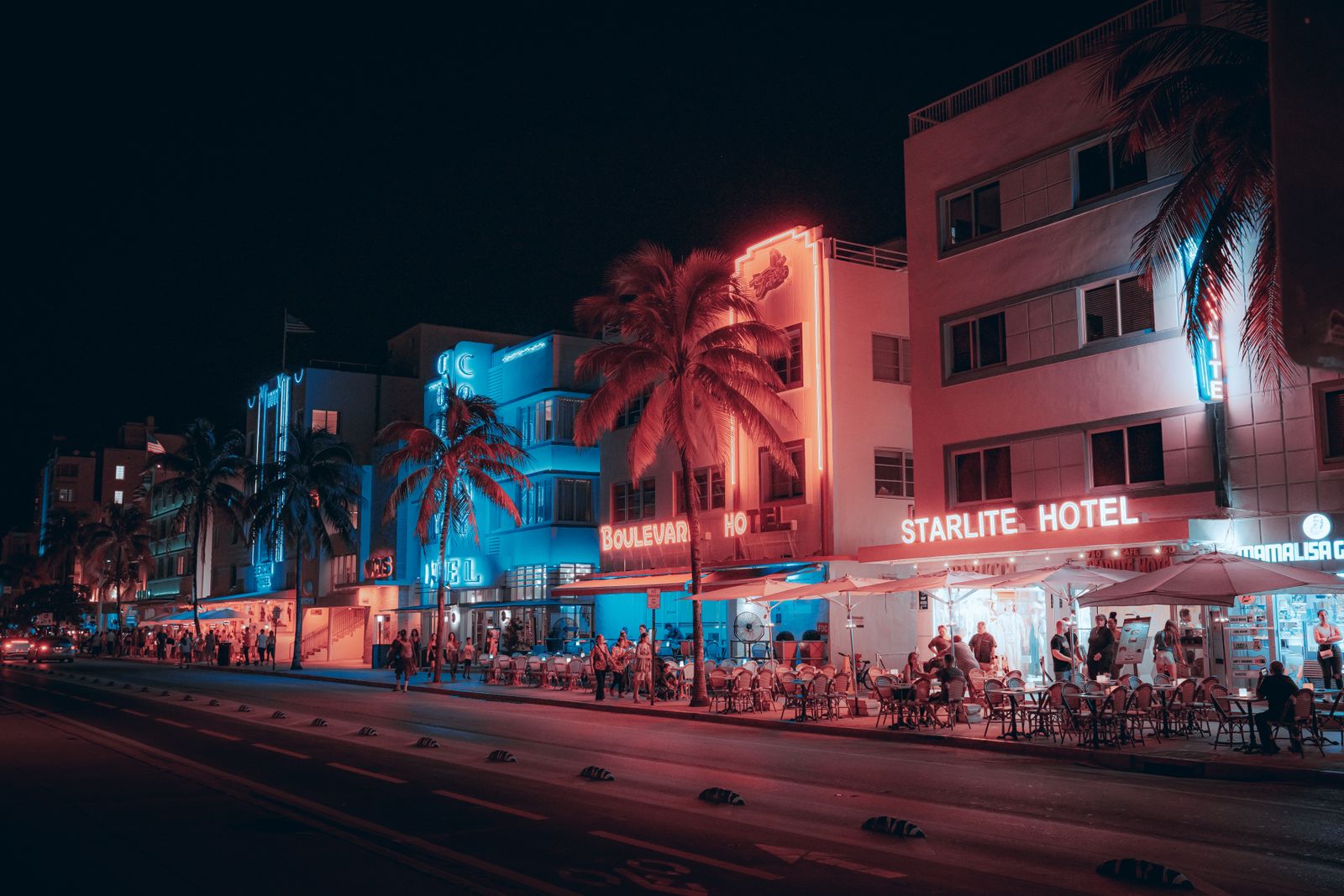 Colorful art deco hotels and a lively street scene on Ocean Drive at night