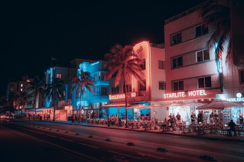 Colorful art deco hotels and a lively street scene on Ocean Drive at night