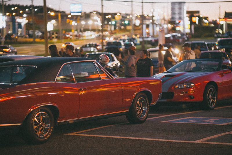 A gathering of classic car enthusiasts showcasing vintage models at night